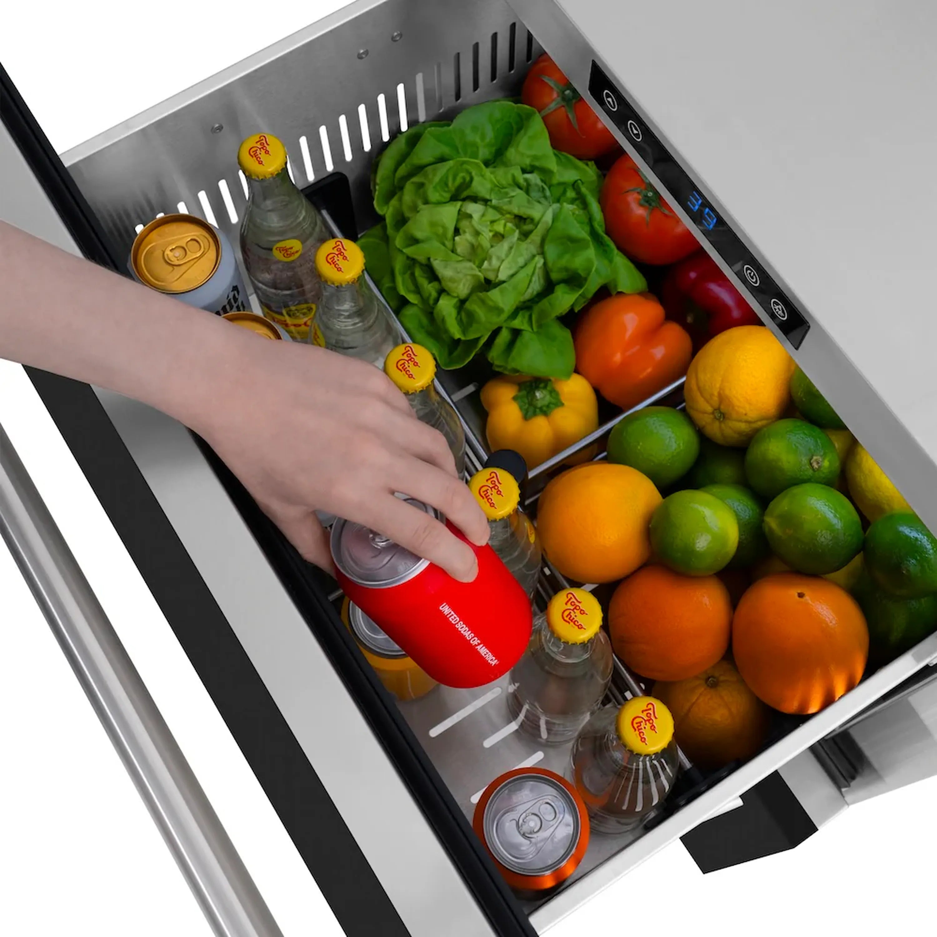 Hand loading a red item into open refrigerator drawer with produce and bottles