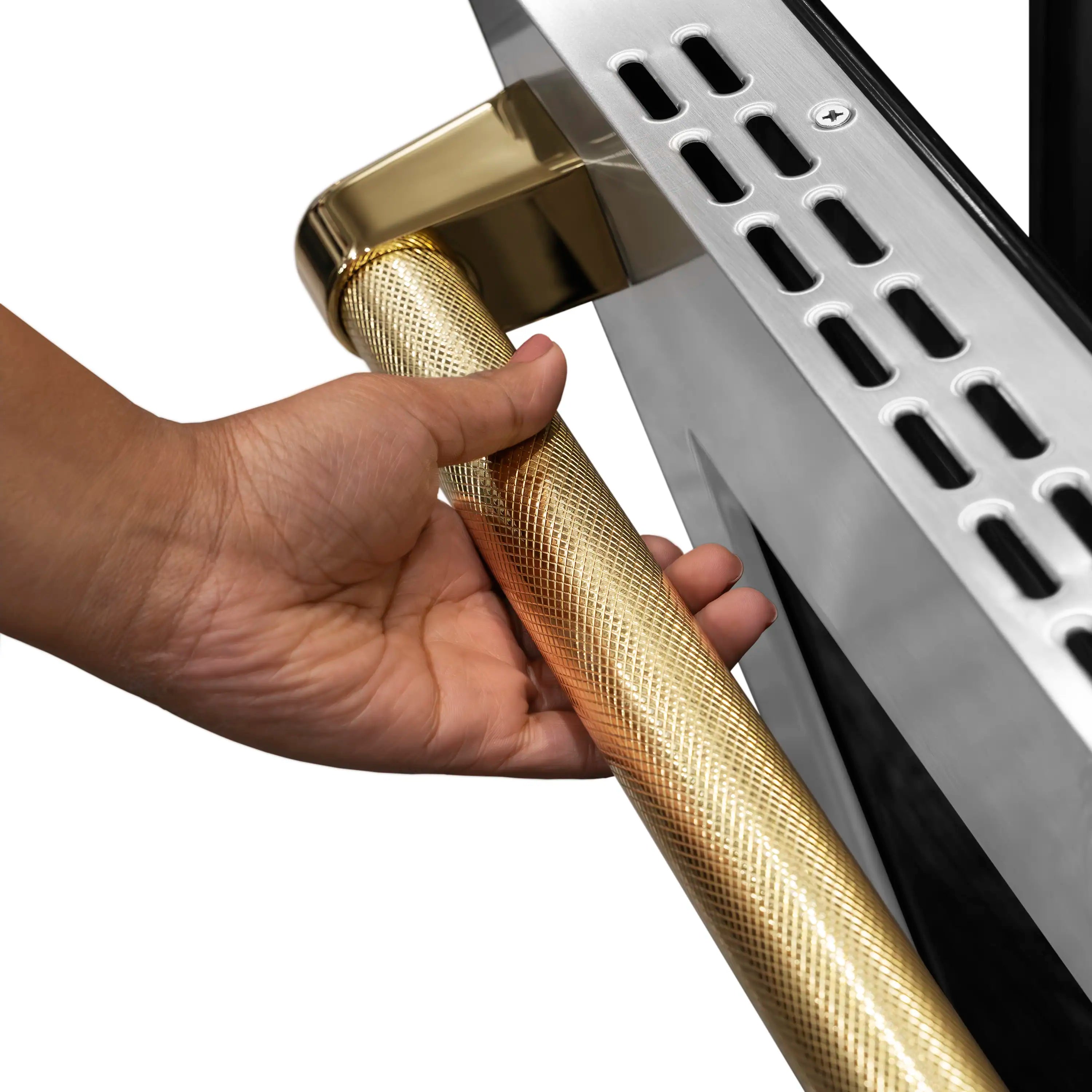 Gold helix handle detail on stainless steel range with hand gripping the handle