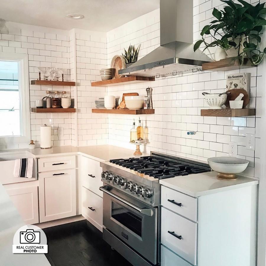 Stainless steel range with oven doors and wall-mounted range hood in a kitchen