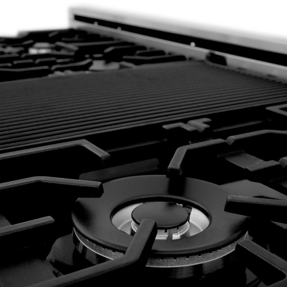 Ridged black griddle insert on satin stainless steel gas cooktop with burner grates