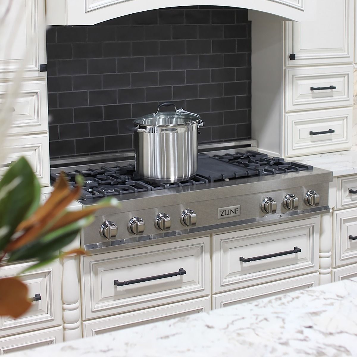 Satin stainless steel gas rangetop with black burner grates and pots on burners