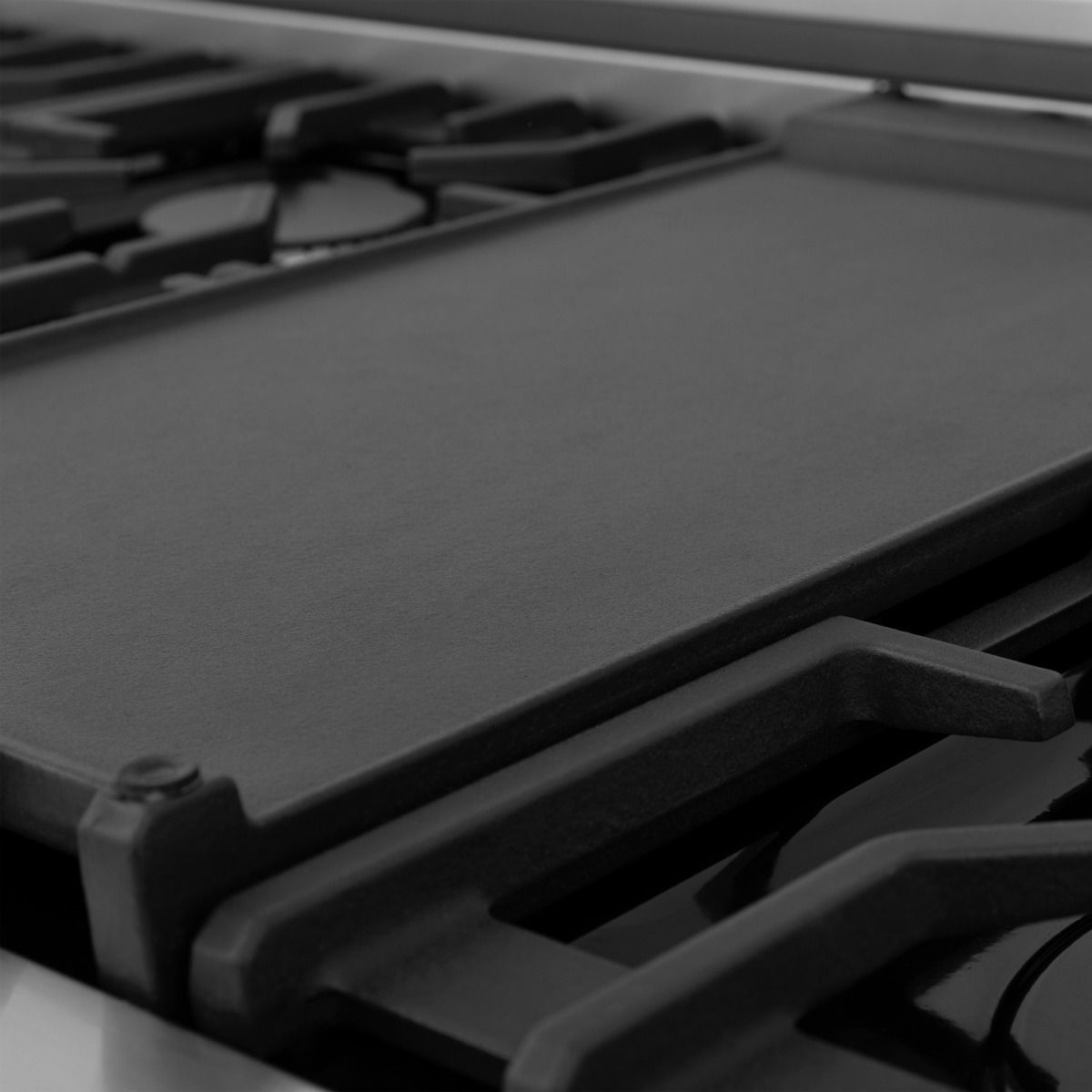 Stainless gas cooktop with black burner grates and smooth cooktop surface
