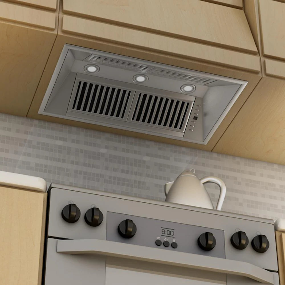 Stainless steel range hood insert installed under cabinets with vent grilles