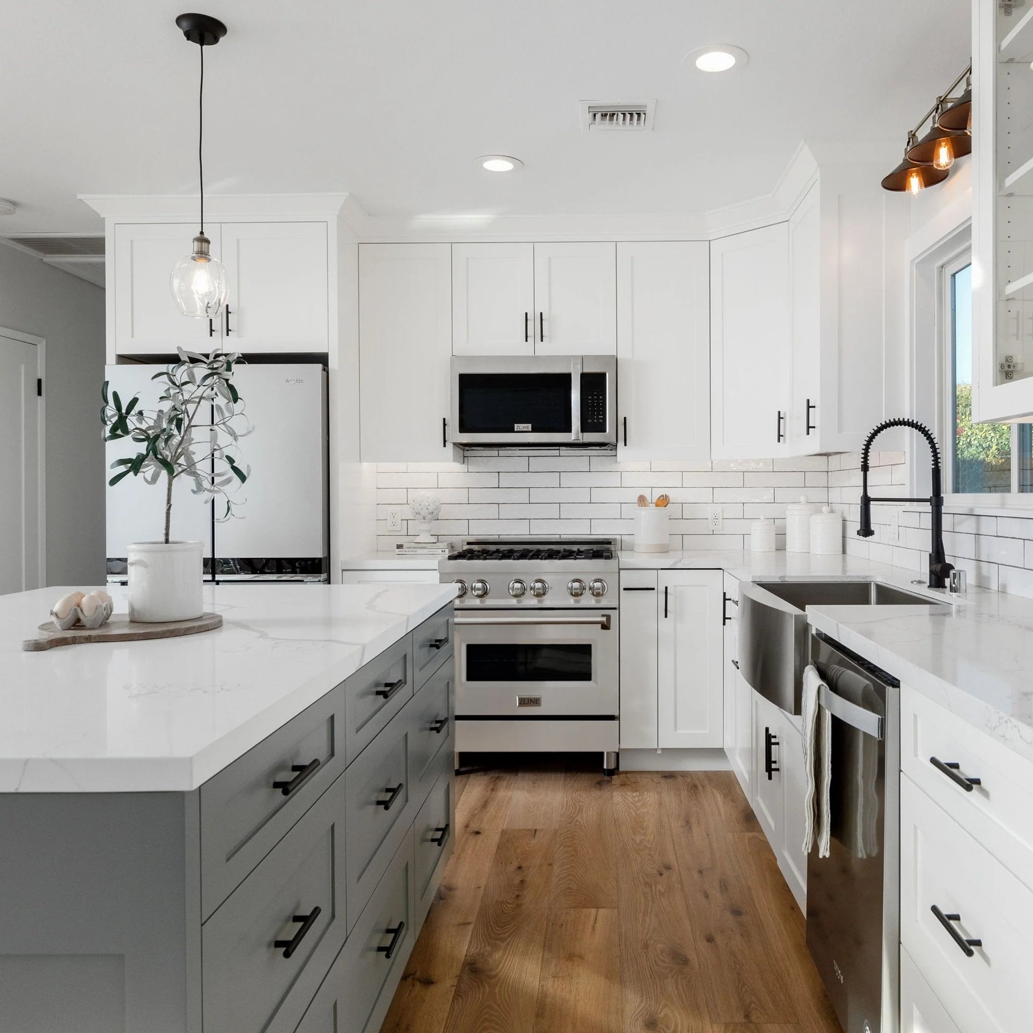 Stainless gas range with over-the-range microwave in a white kitchen
