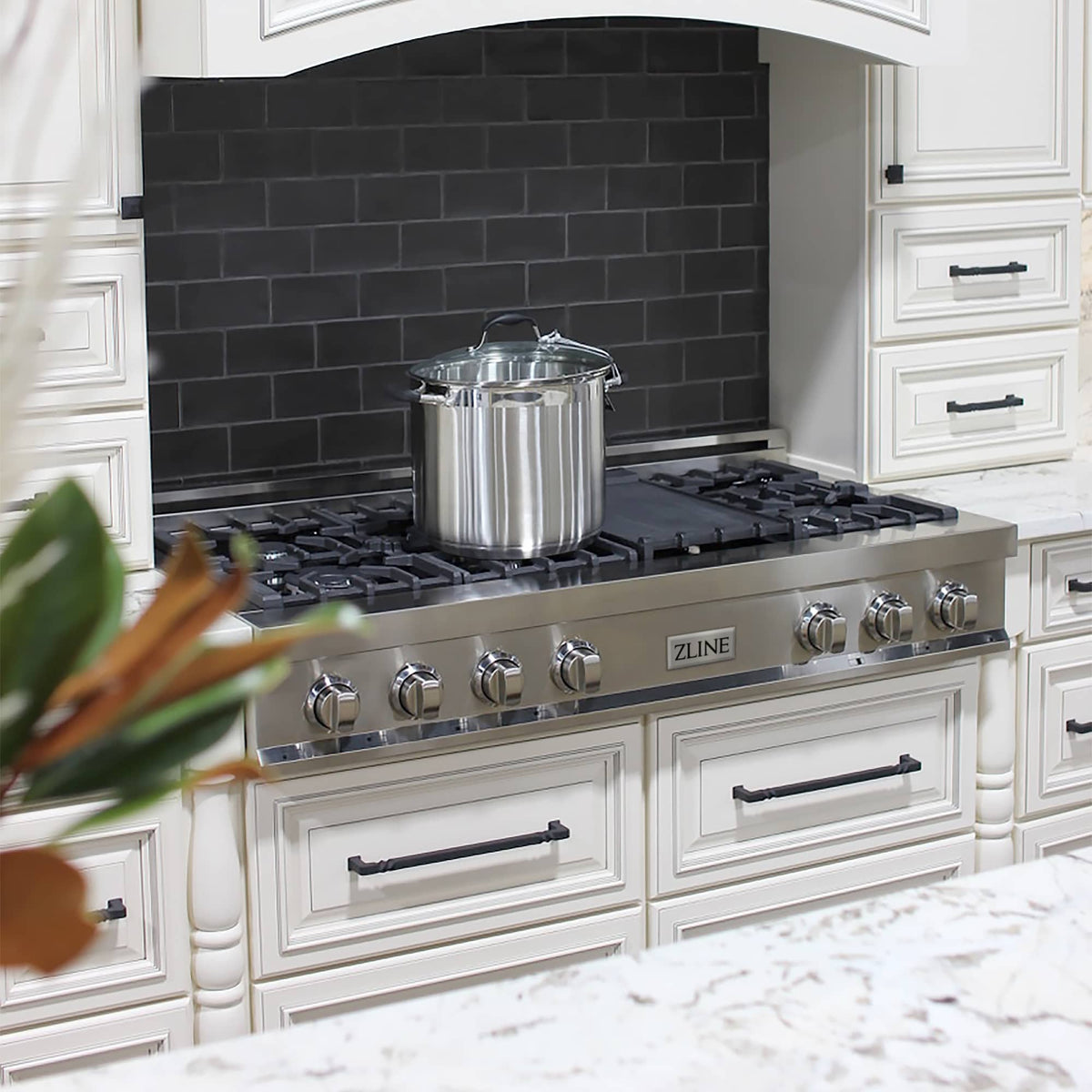 Stainless steel gas rangetop with black grates and center cooking pot