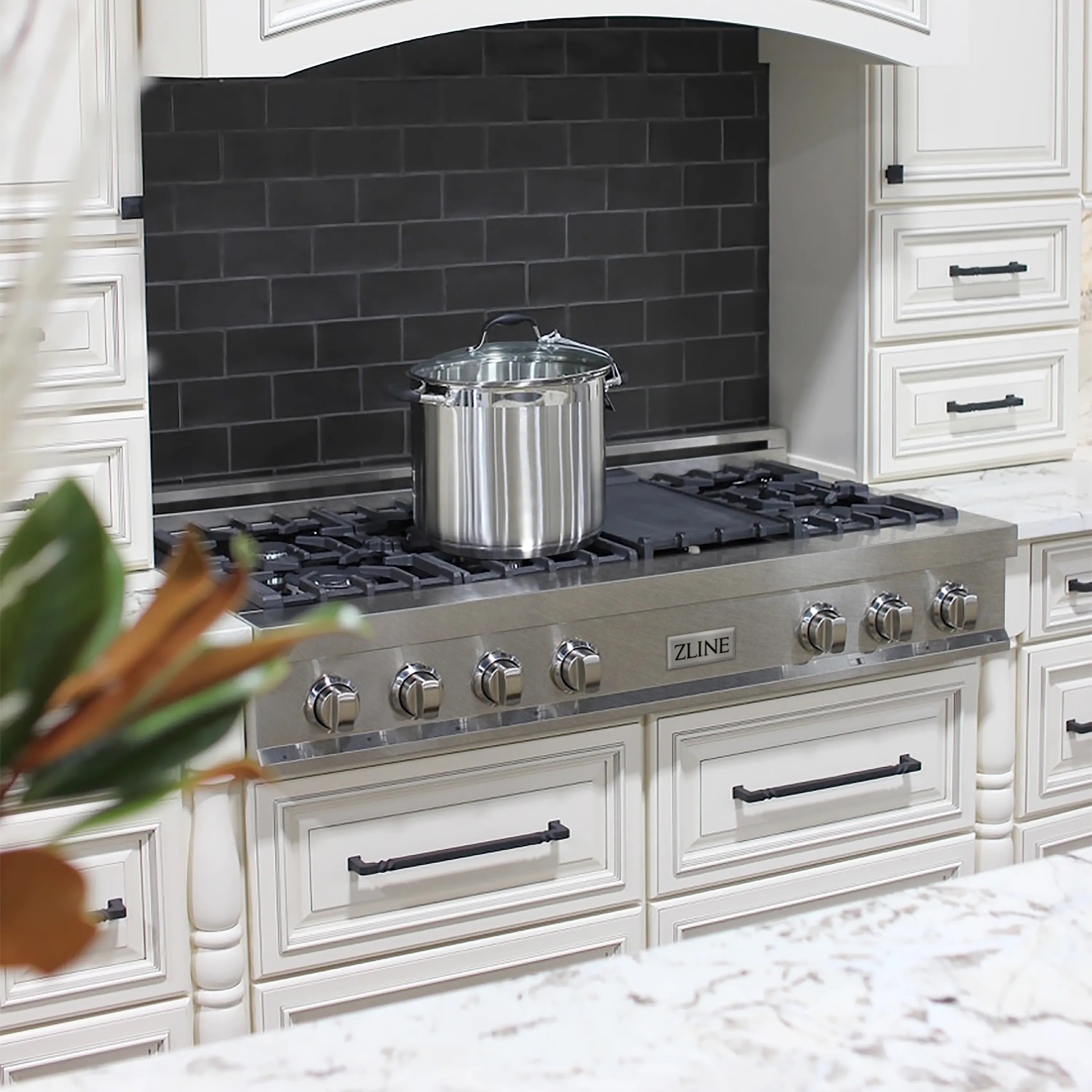 7-burner gas stovetop with griddle on satin stainless steel in a kitchen