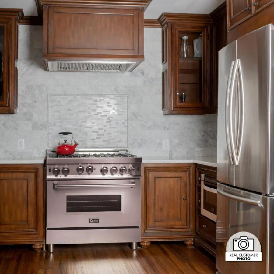 Stainless steel ducted range hood insert above a freestanding gas range