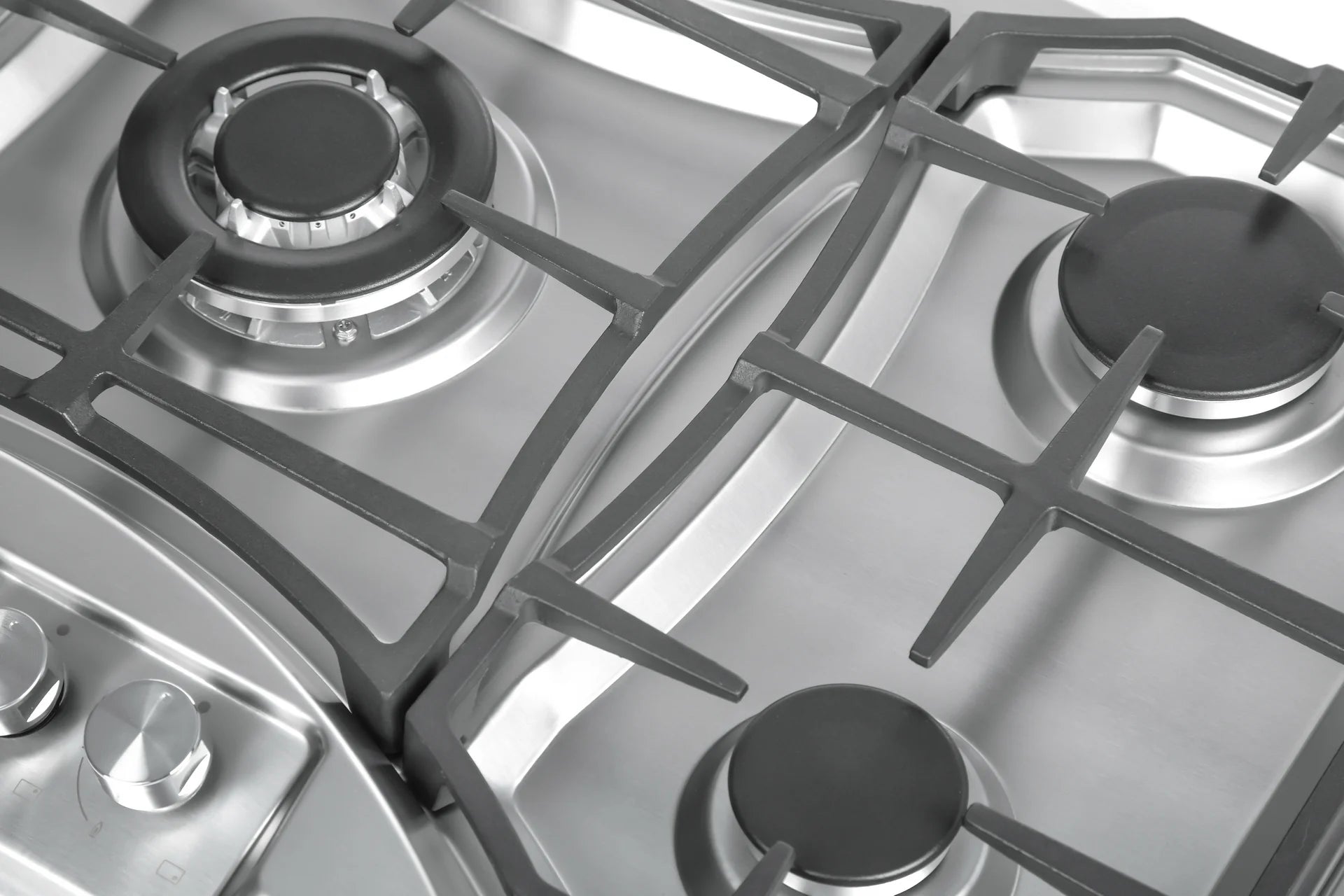 Stainless steel gas cooktop burner close-up with cast-iron grate and control knobs