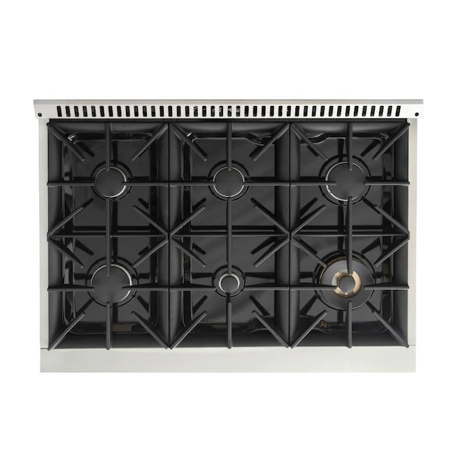 Cooktop view with six black burner grates and gold burner cap on white range