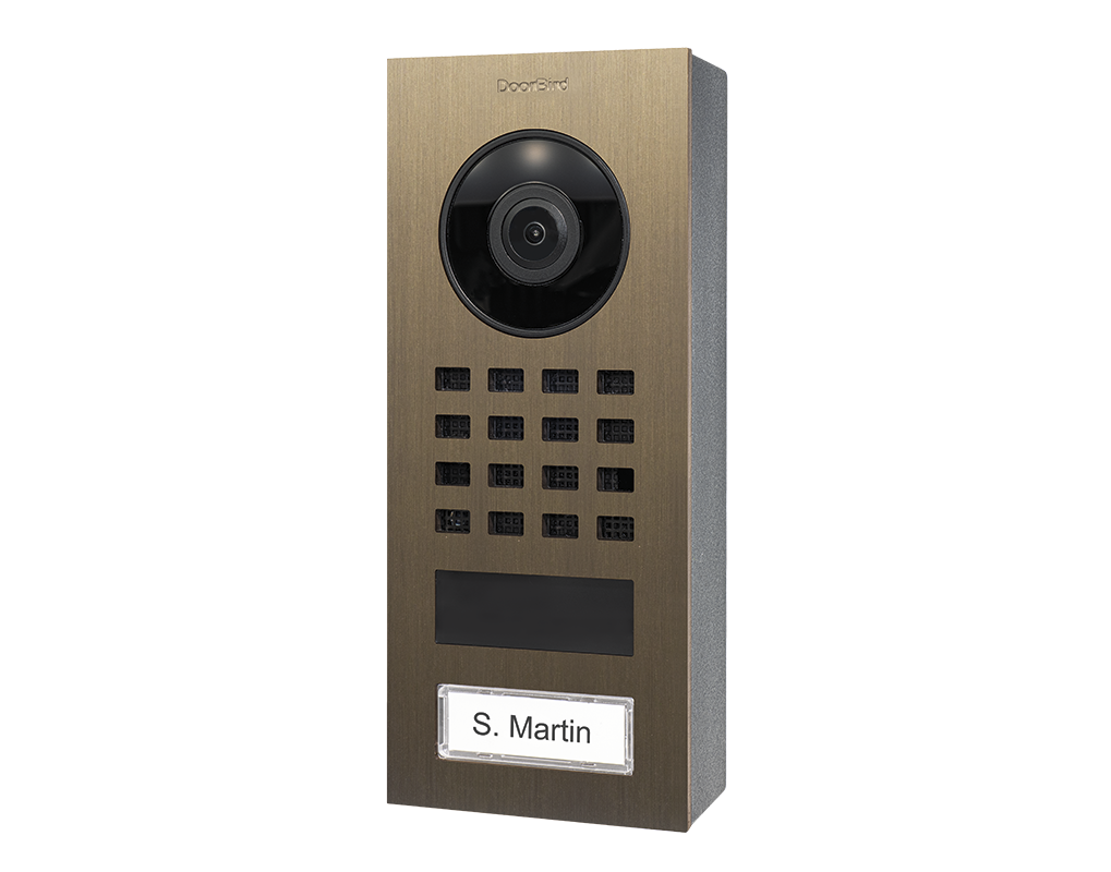 DoorBird surface-mount video intercom, burnished brass face with camera lens and keypad