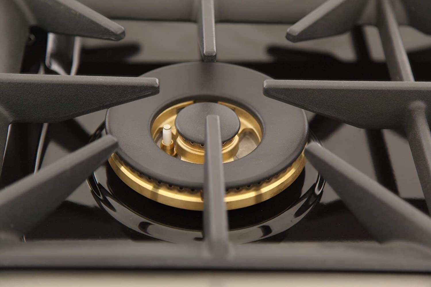 Gas burner with brass-colored ring and black grate, viewed from above