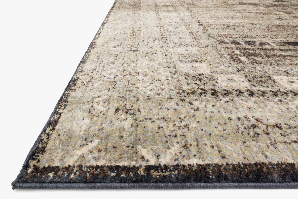 Transitional rug corner with textured abstract weave in gray and beige, dark binding edge.