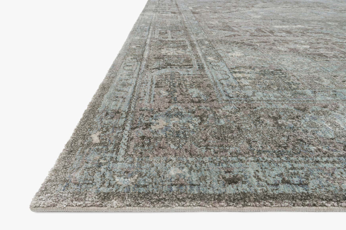 Stone and blue power-loomed rug with distressed geometric border, angled
