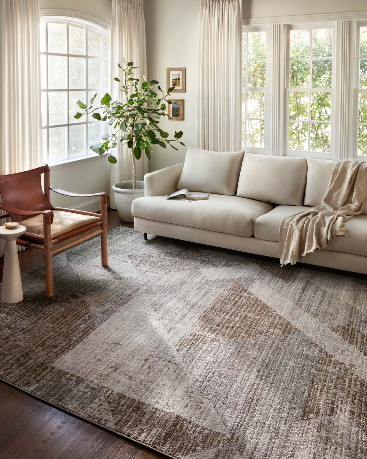 Geometric pattern rug in stone and bark tones, laid on dark wood flooring