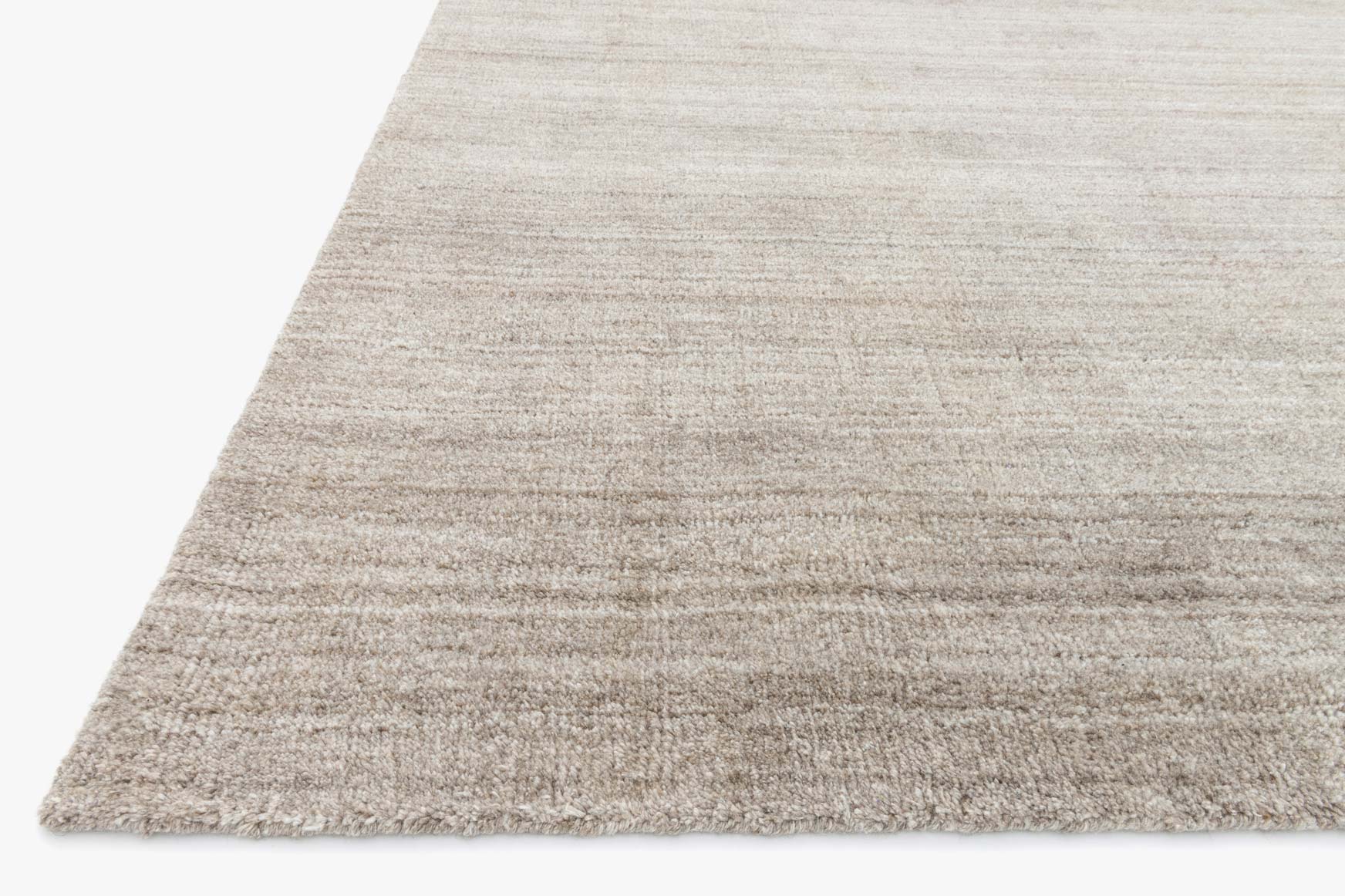 Corner view of hand-loomed transitional rug in light mocha with low-cut textured weave