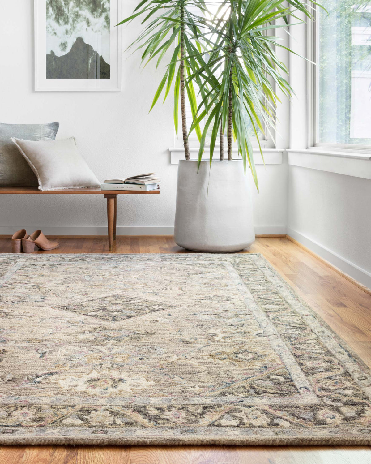 Traditional hooked rug in light blue and beige with distressed pattern and border