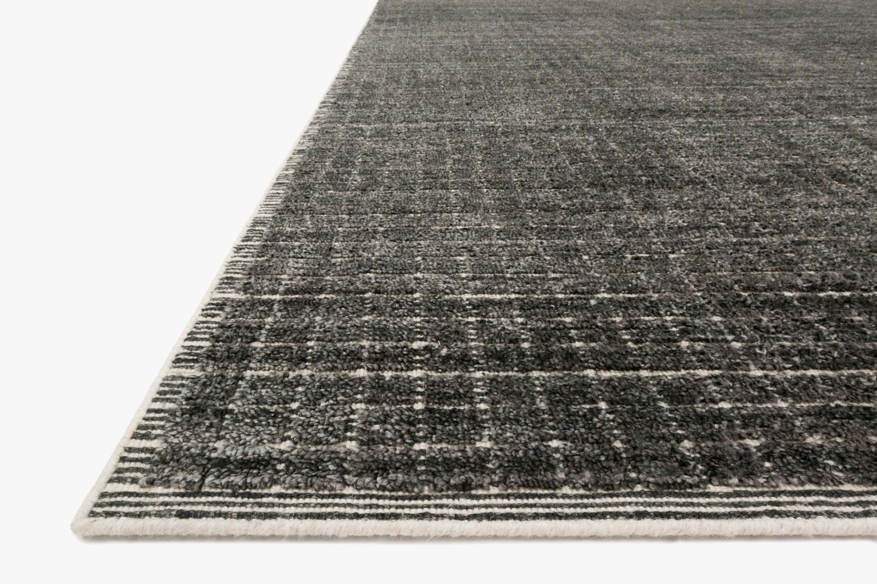 Charcoal hand-loomed rug with textured woven lines and flat edge border detail.