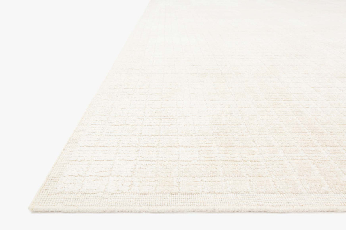 Ivory hand-loomed rug corner detail with low-profile woven texture