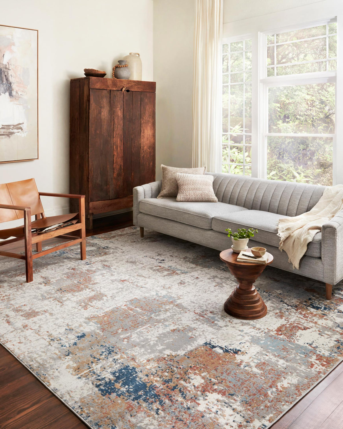 Ivory abstract area rug, power-loomed, with blue and rust speckled texture