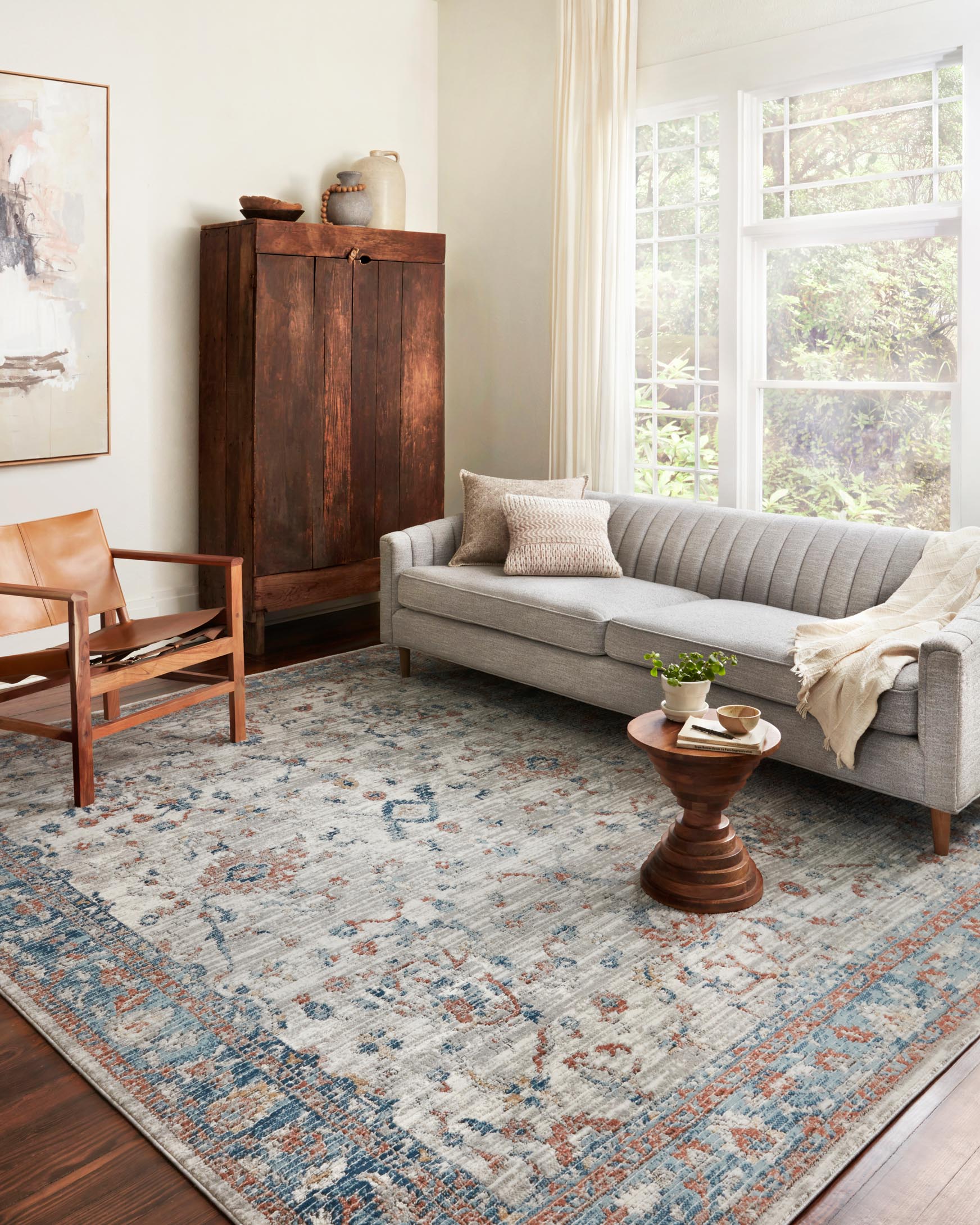 Rectangular rug with distressed motif pattern in light dove, blue, and warm rust tones