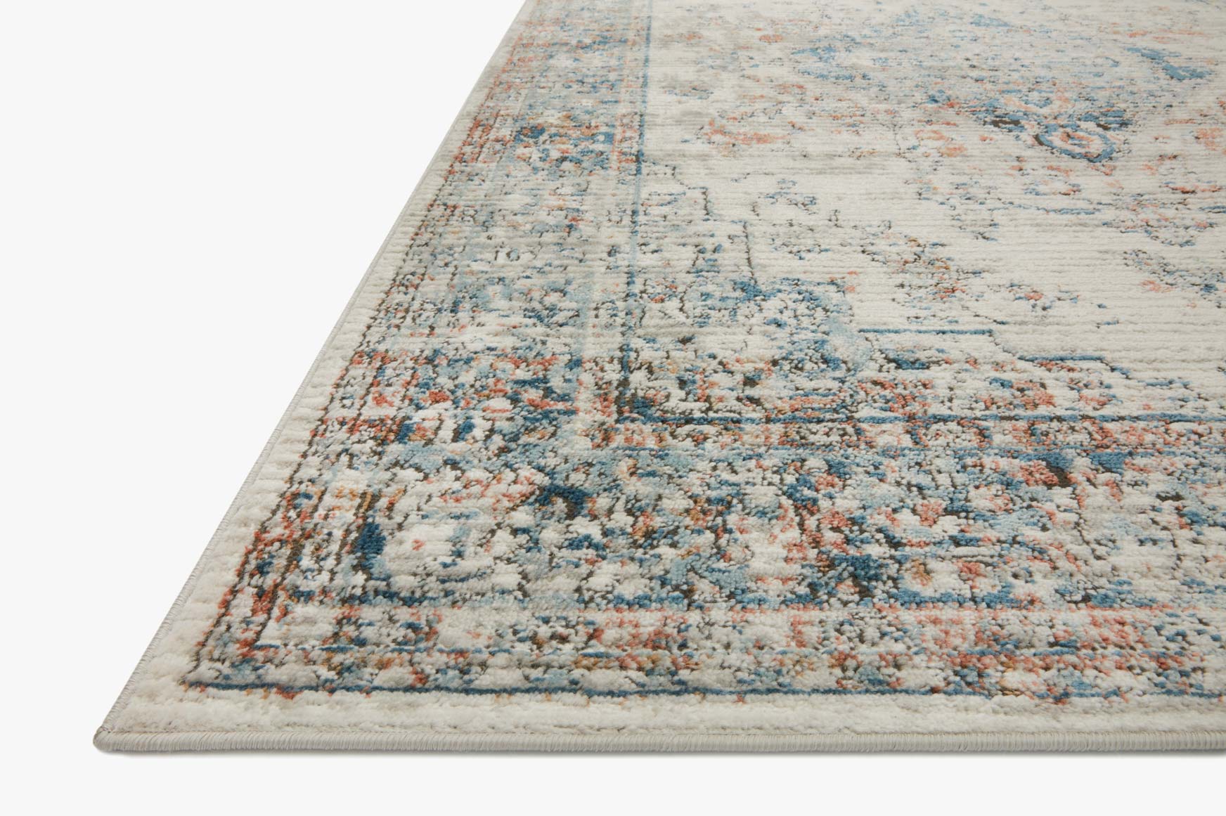 Ivory rug with blue and orange distressed motif, angled corner view, low-pile weave