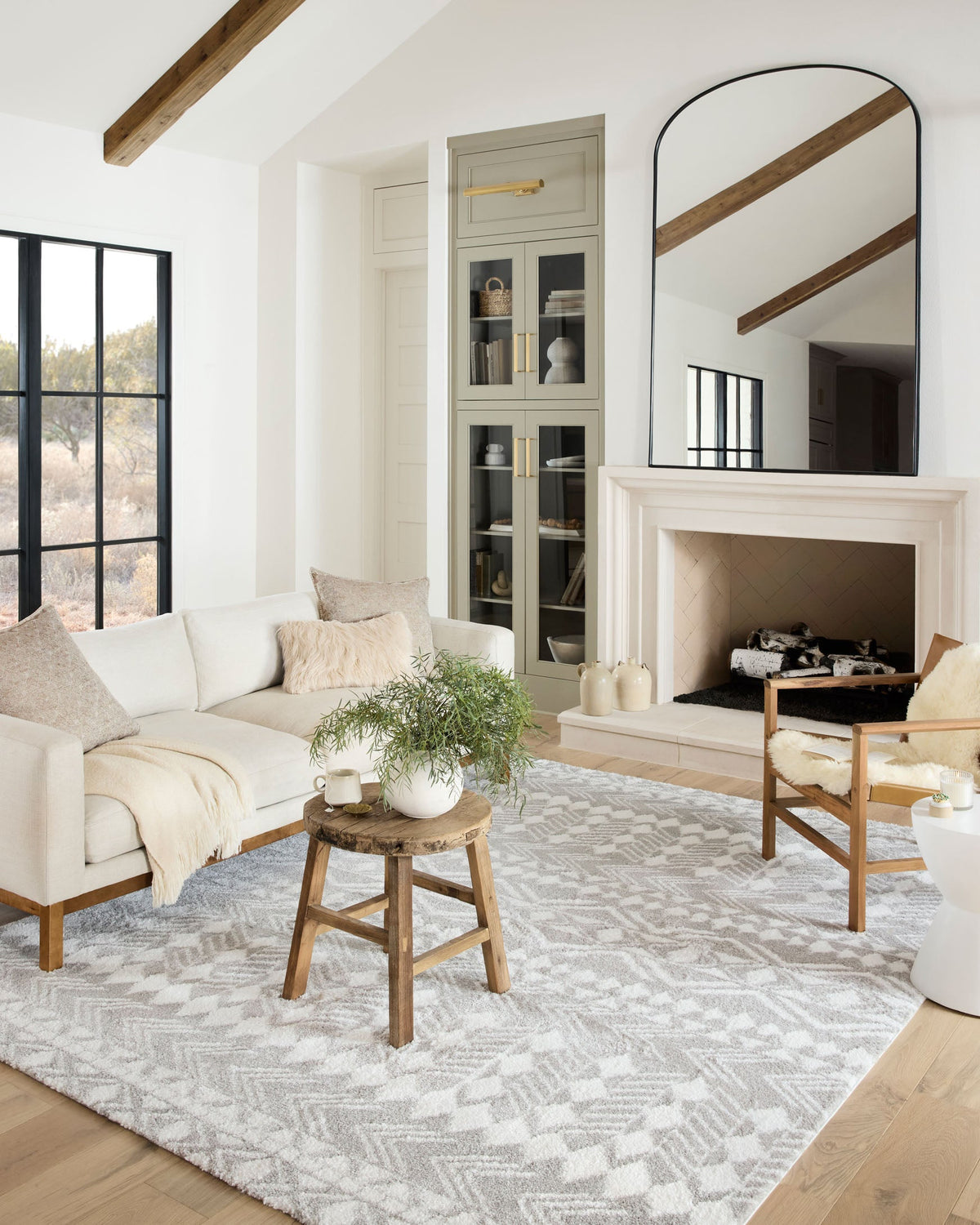 Grey and white shag rug featuring geometric pattern, laid in a living room.