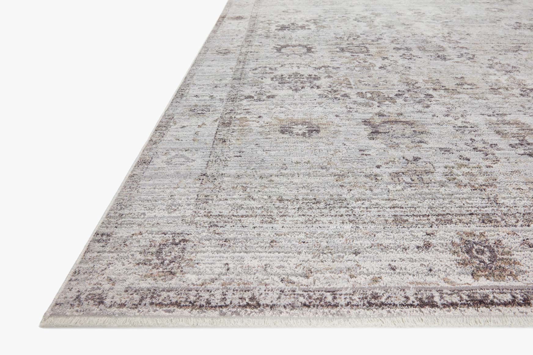 Stone and charcoal area rug with distressed pattern, shown from corner view