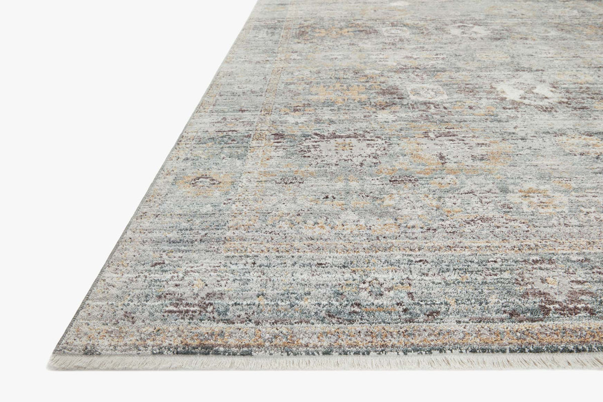 Teal and gold rug border with abstract stripe-like bands, low-profile woven texture.