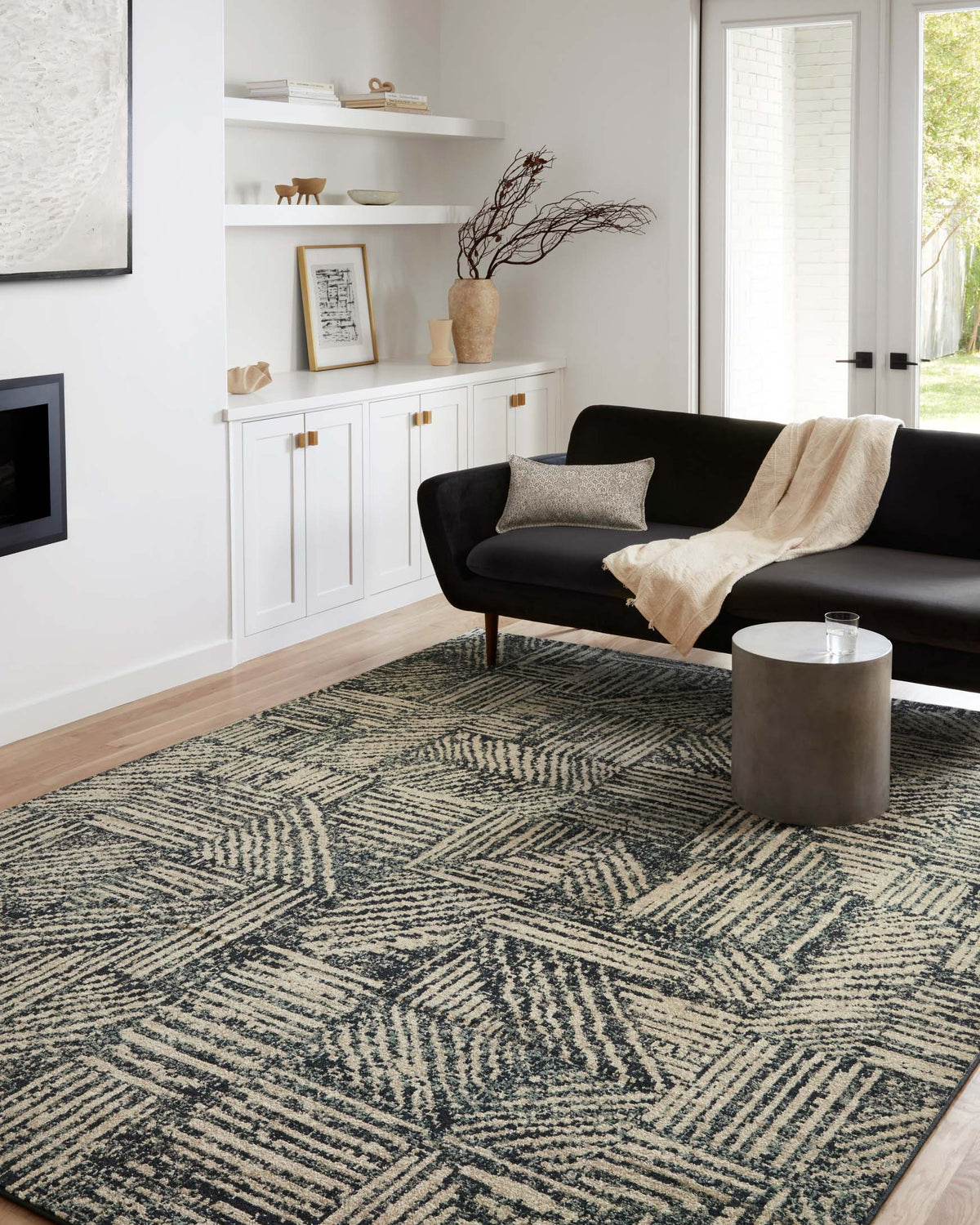 Geometric midnight and taupe rug in a living room setting with patterned surface