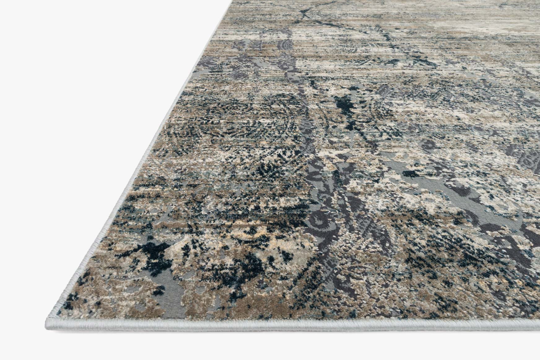 Abstract power-loomed rug corner showing taupe and blue distressed motif