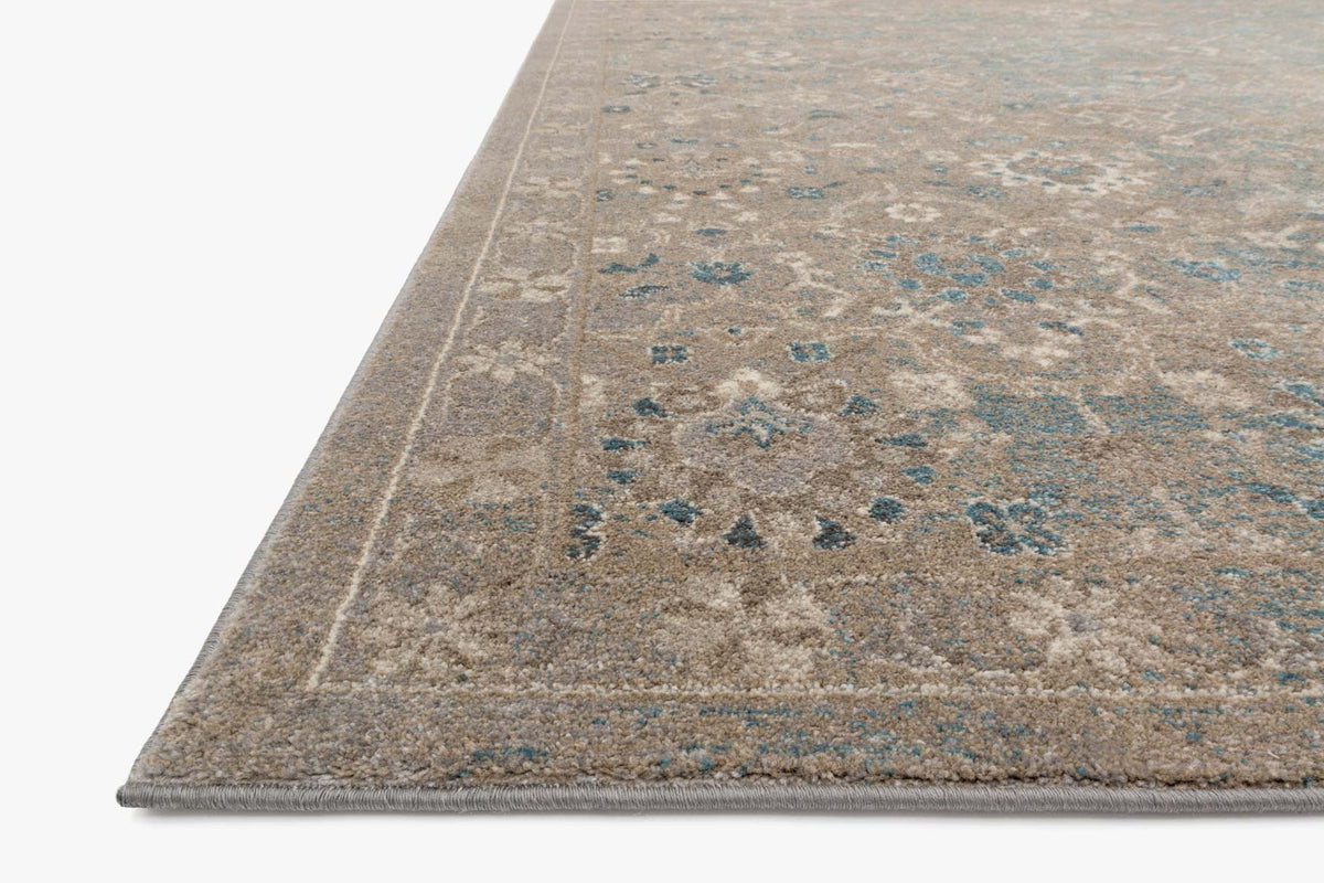 Power-loomed area rug border detail, blue-gray motifs on heathered beige ground