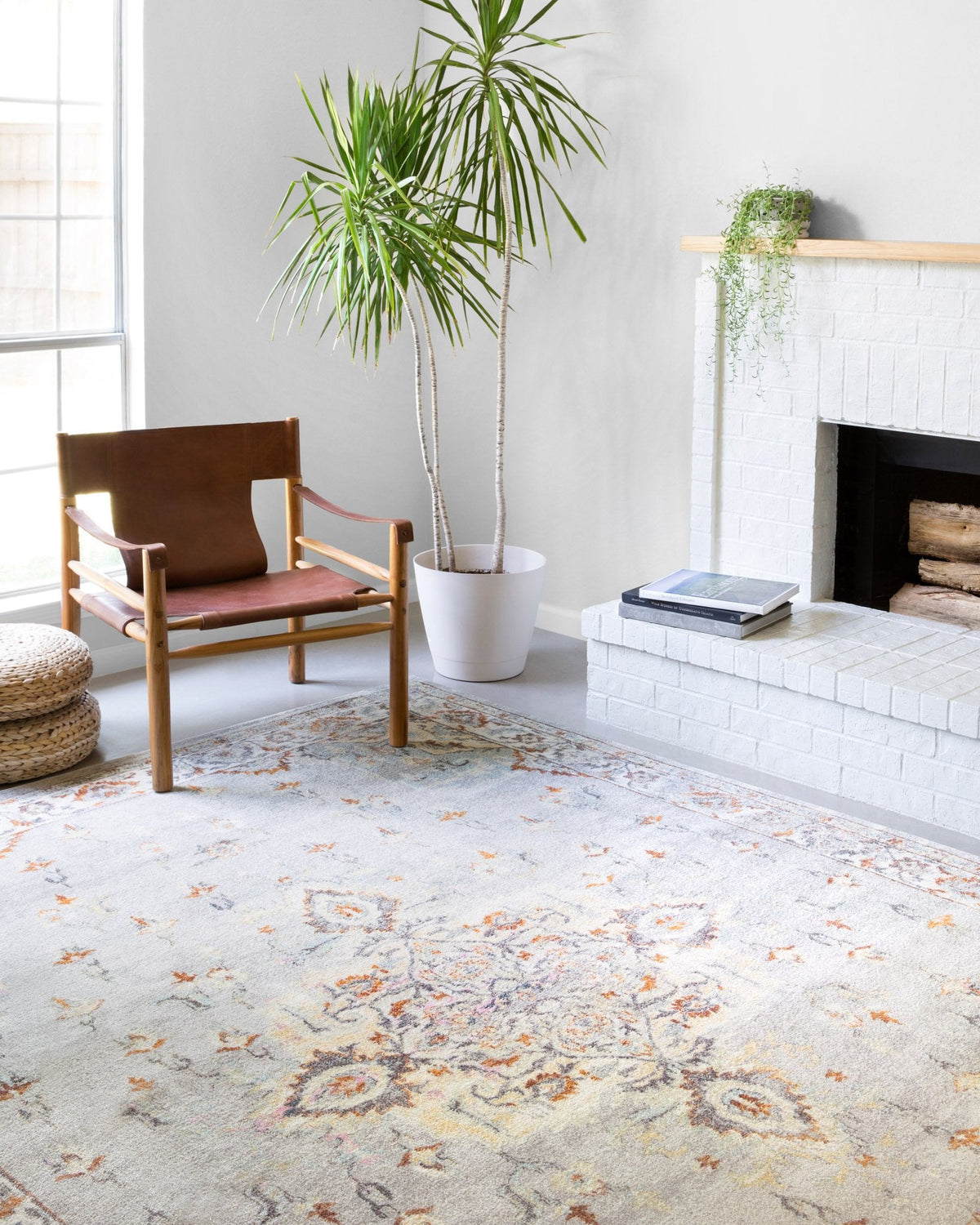 Grey and ivory area rug with distressed ornate pattern and orange highlights