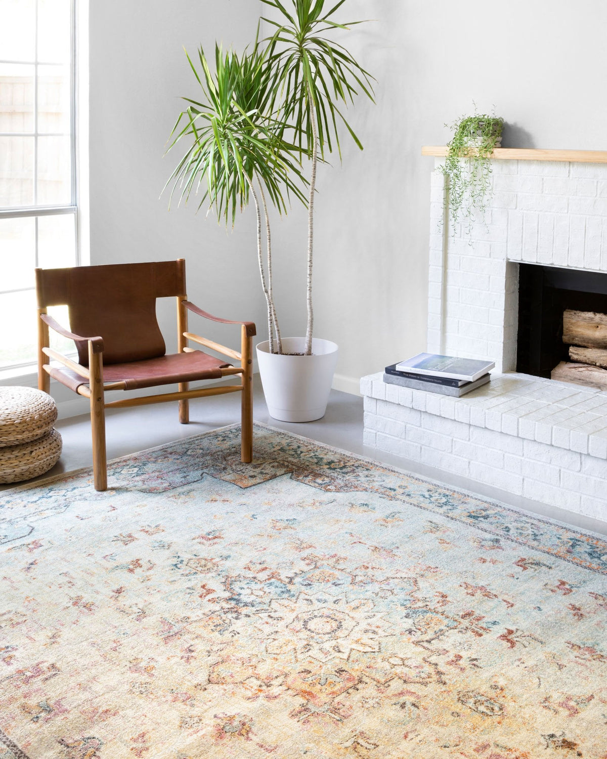 Ornate mist rug styled in a living room with fireplace, chair, and potted plant