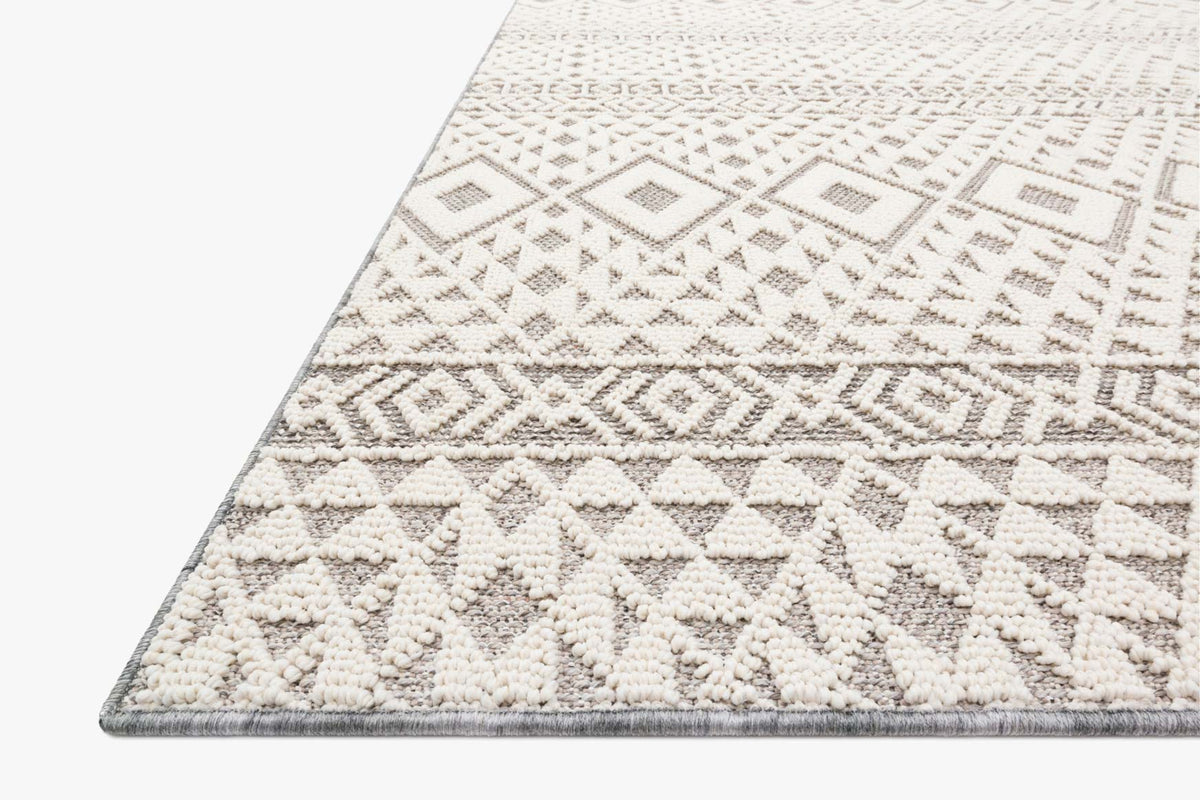 Ivory rug corner with silver geometric motifs and textured pile