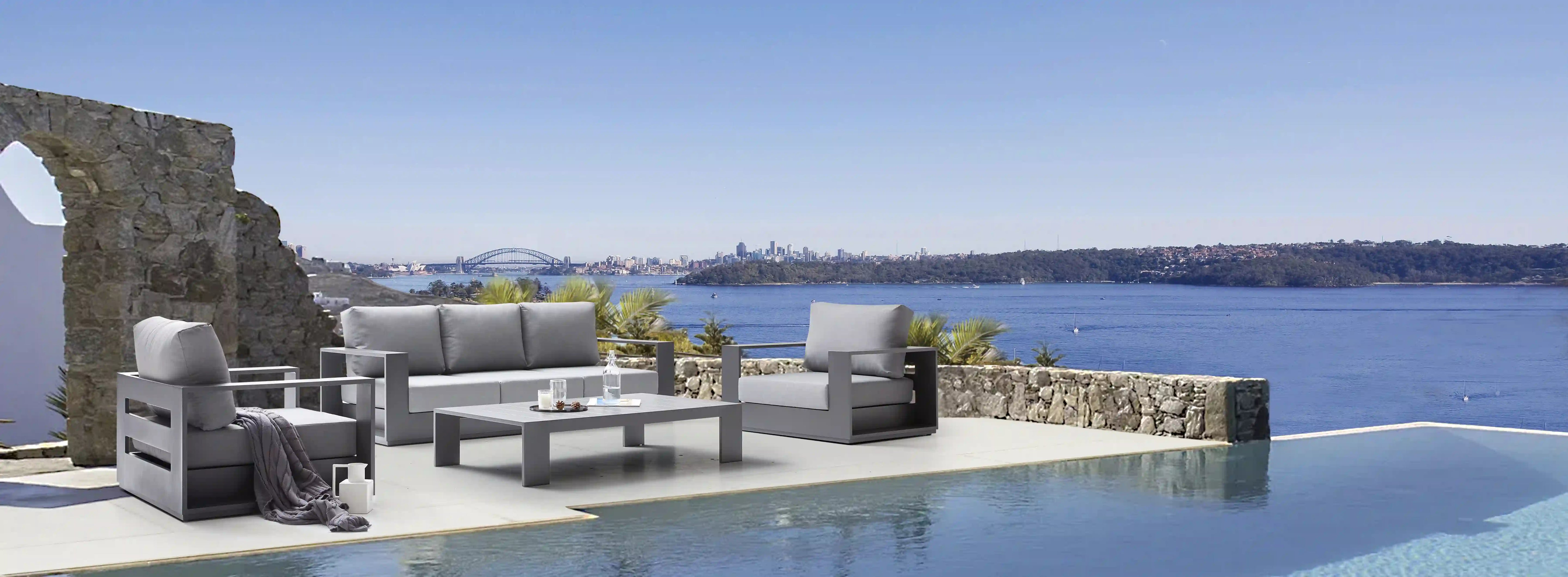 Outdoor seating set with gray sofa, matching chairs, and dark gray coffee table
