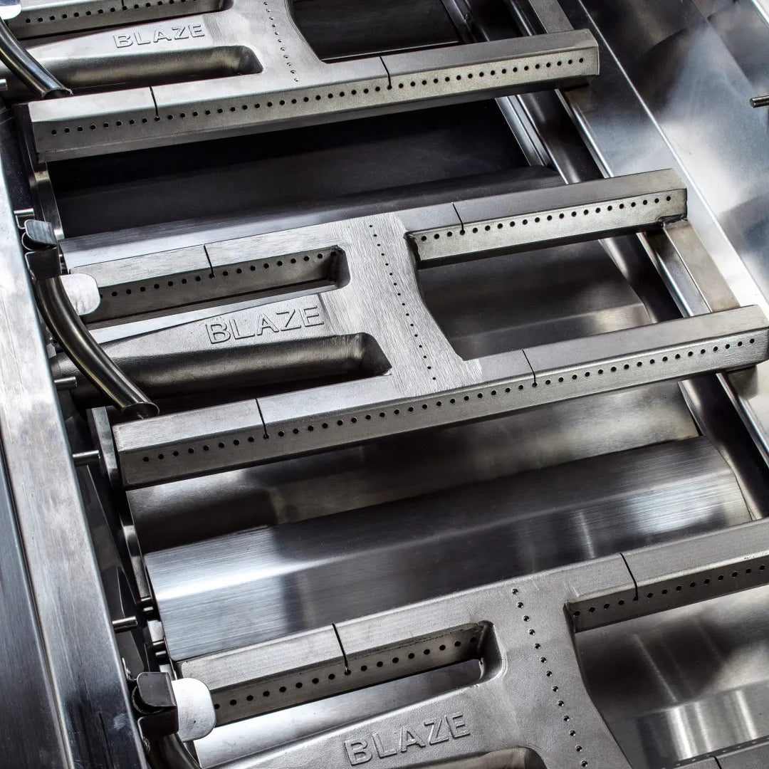 Stainless steel grill burner bars with Blaze logo and vent holes