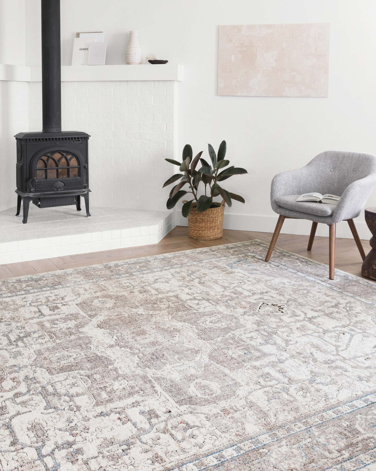 Transitional rug in ivory and stone with detailed geometric medallion and blue border.