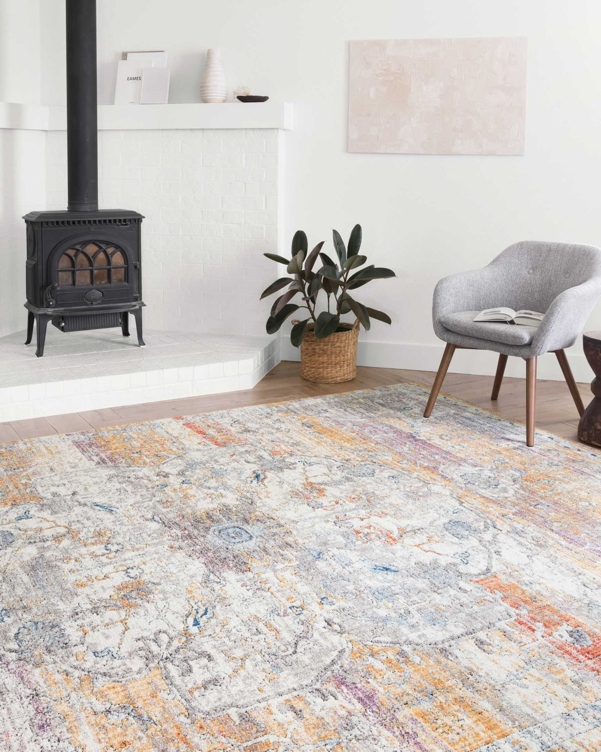Abstract area rug with light gray and beige base, blue details, and orange accents