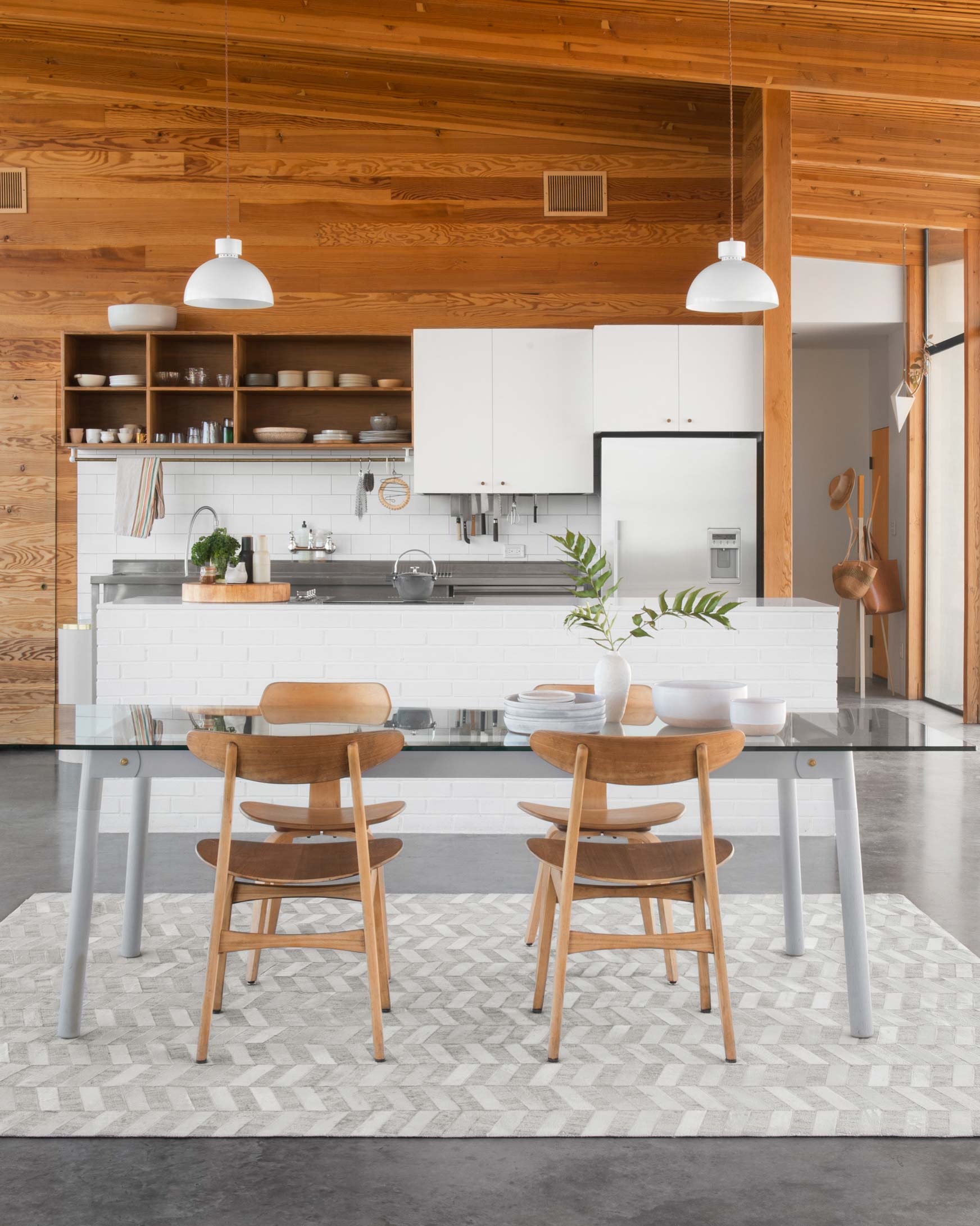Grey and ivory hand-stitched rug with chevron stripe pattern, shown on a flat weave