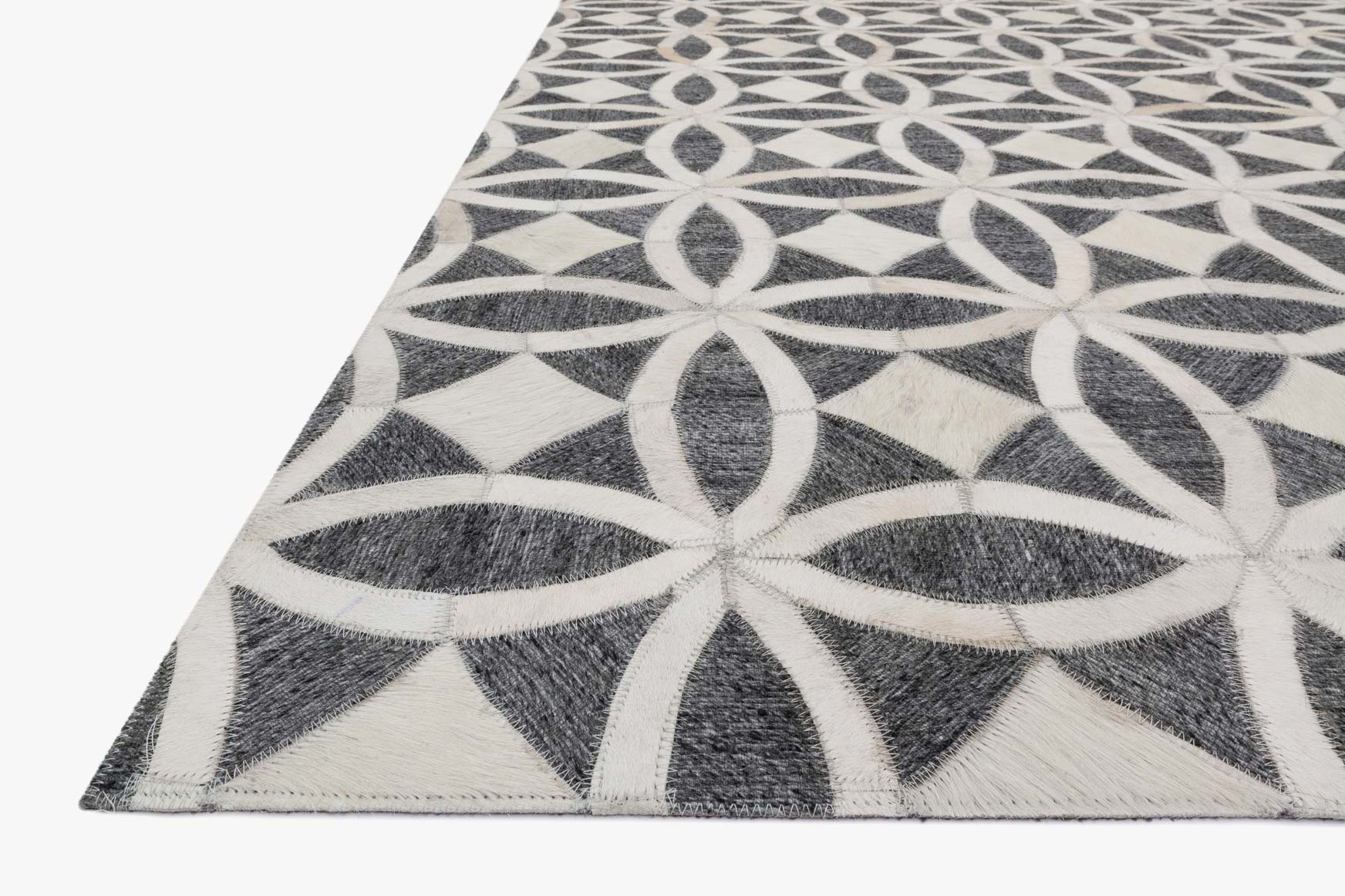Hand-stitched rug corner detail, graphite and ivory star/flower geometric motif