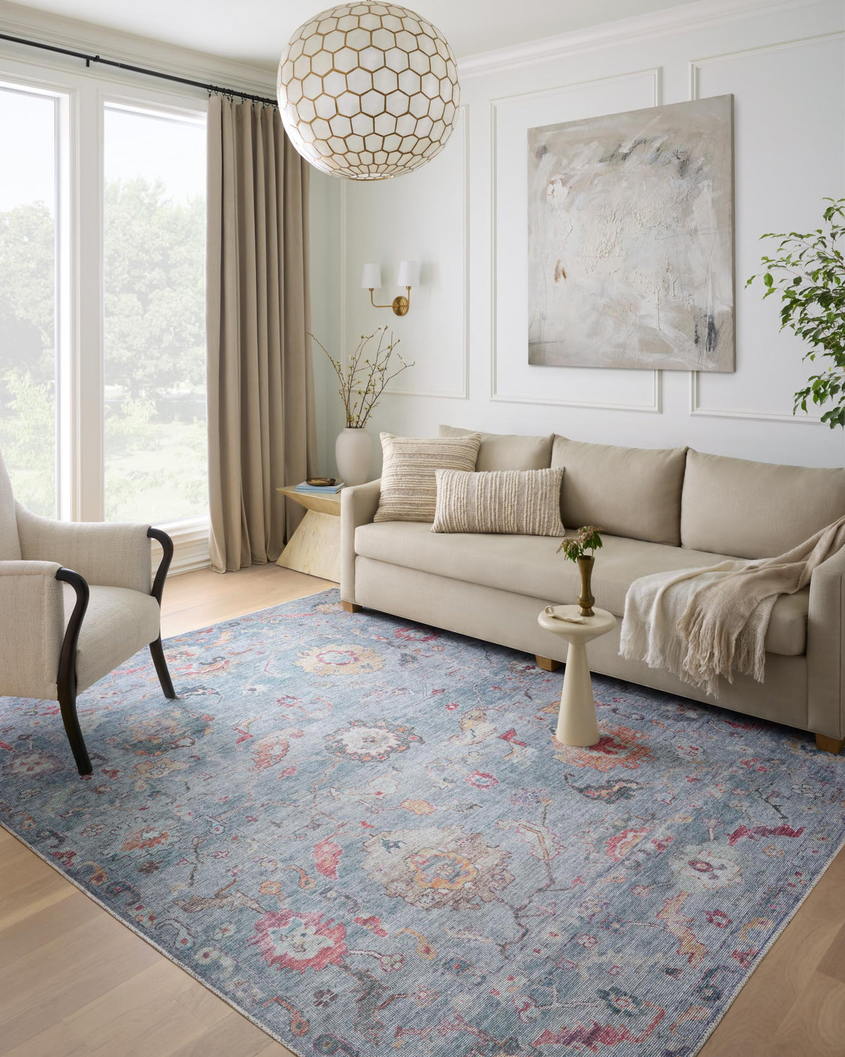 Denim blue rug with faded red and tan ornate motifs on a living room floor