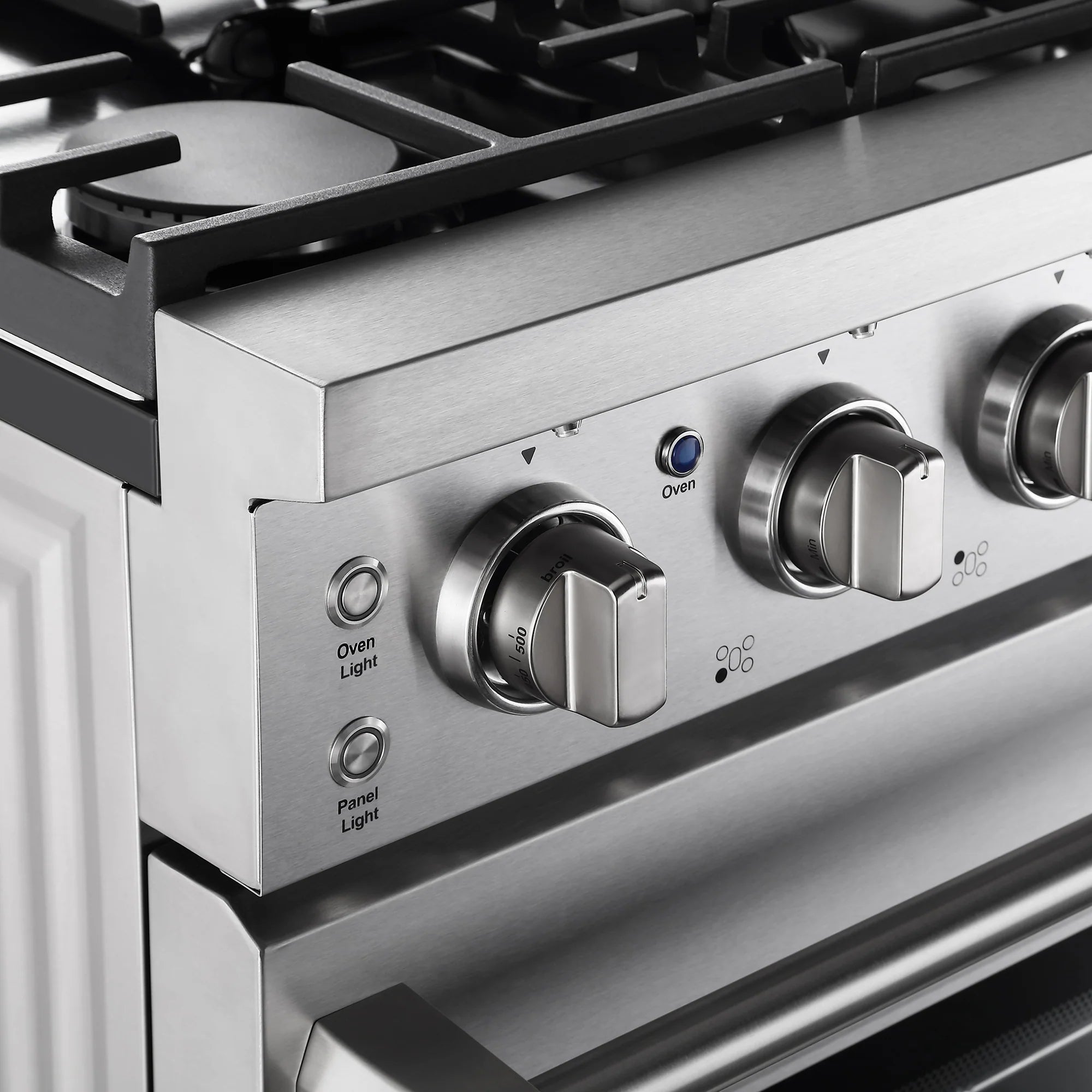 Stainless steel control panel with oven knobs and light indicator