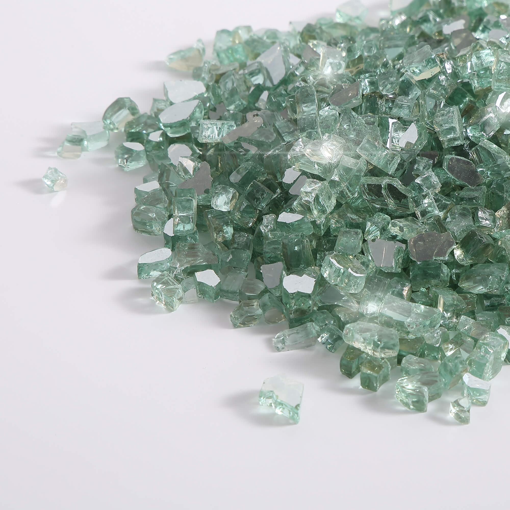 Radiant jade green tempered reflective fire glass chunks, scattered on a surface.
