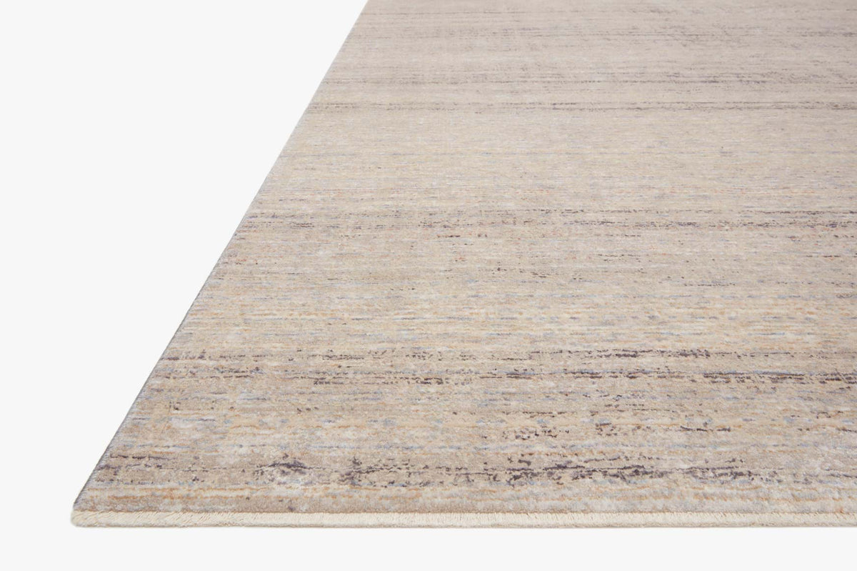 Power loomed area rug with beige base and muted sky-blue bands at corner