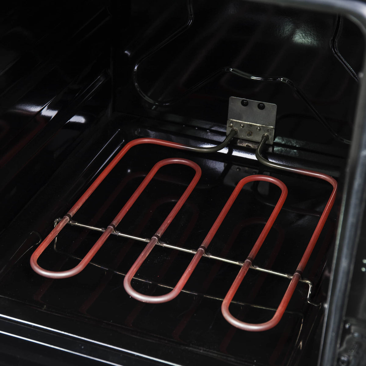 Electric oven heating elements with copper-colored coil near oven rack inside the range