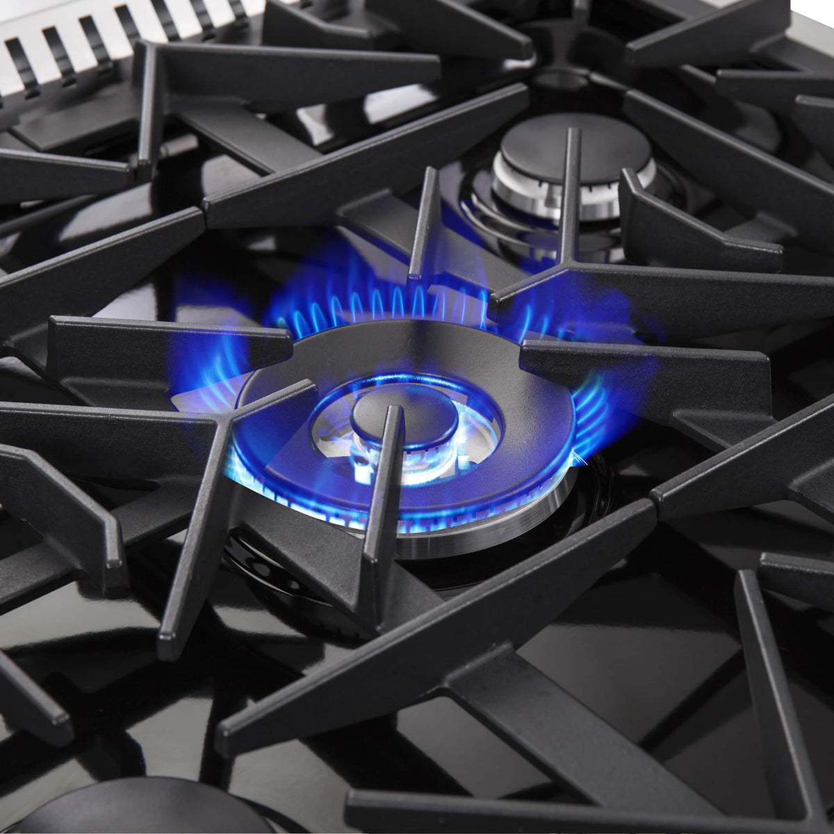 Gas burner with blue flame on stainless steel range cooktop
