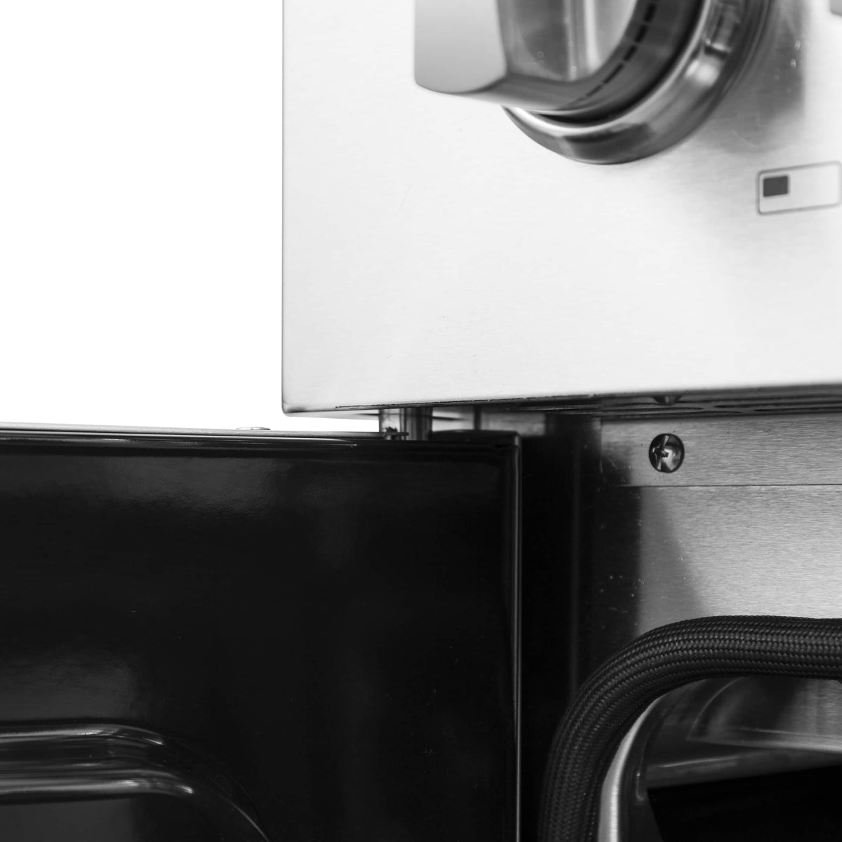 Black oven door panel corner with stainless trim and gas line conduit