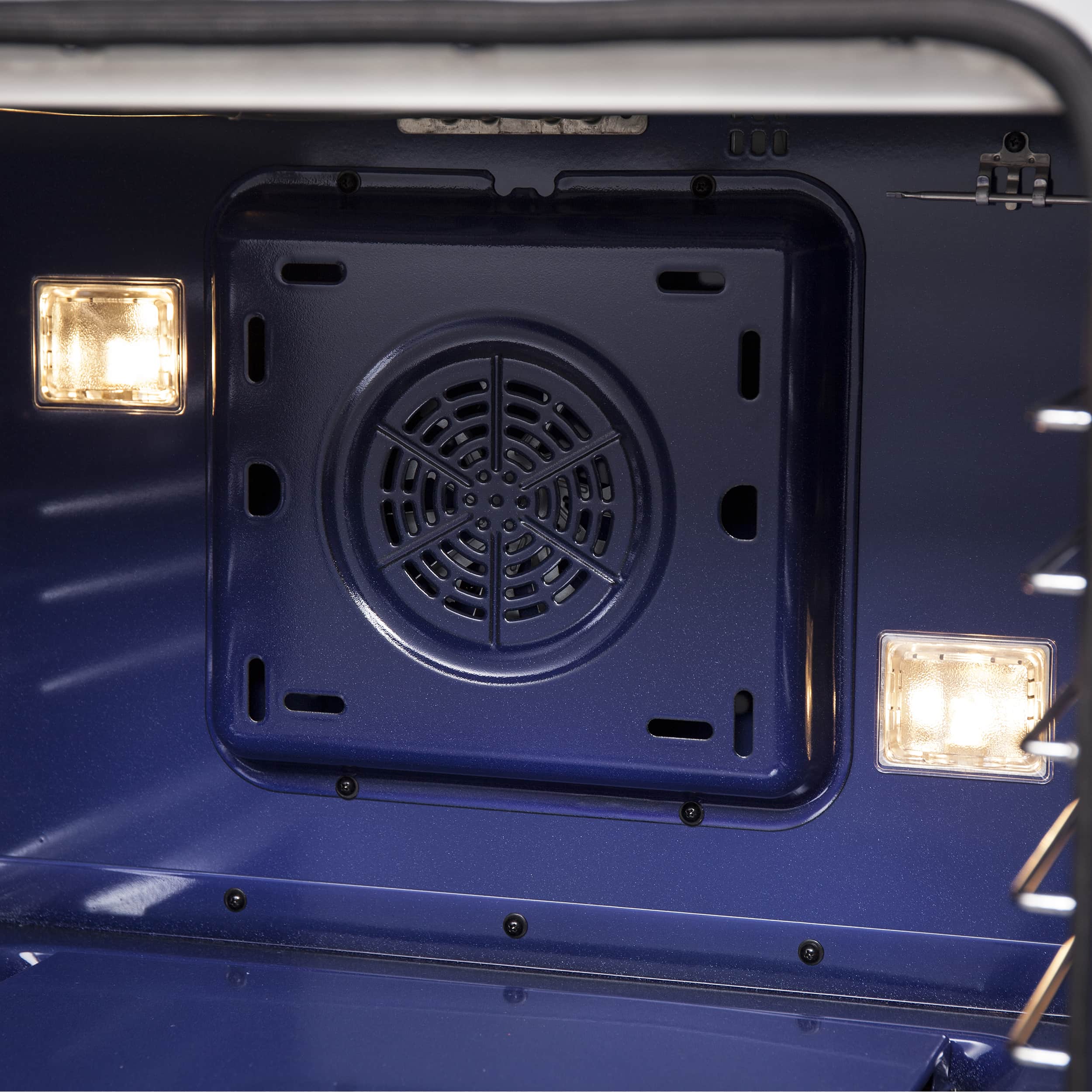 Oven cavity with black fan vent and illuminated side oven lights