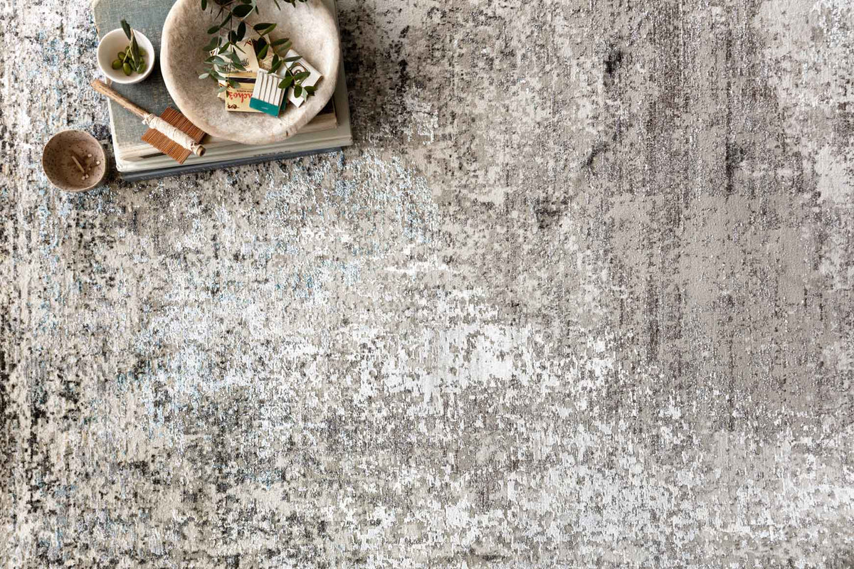 Transitional rug in light gray with blue speckled abstract texture