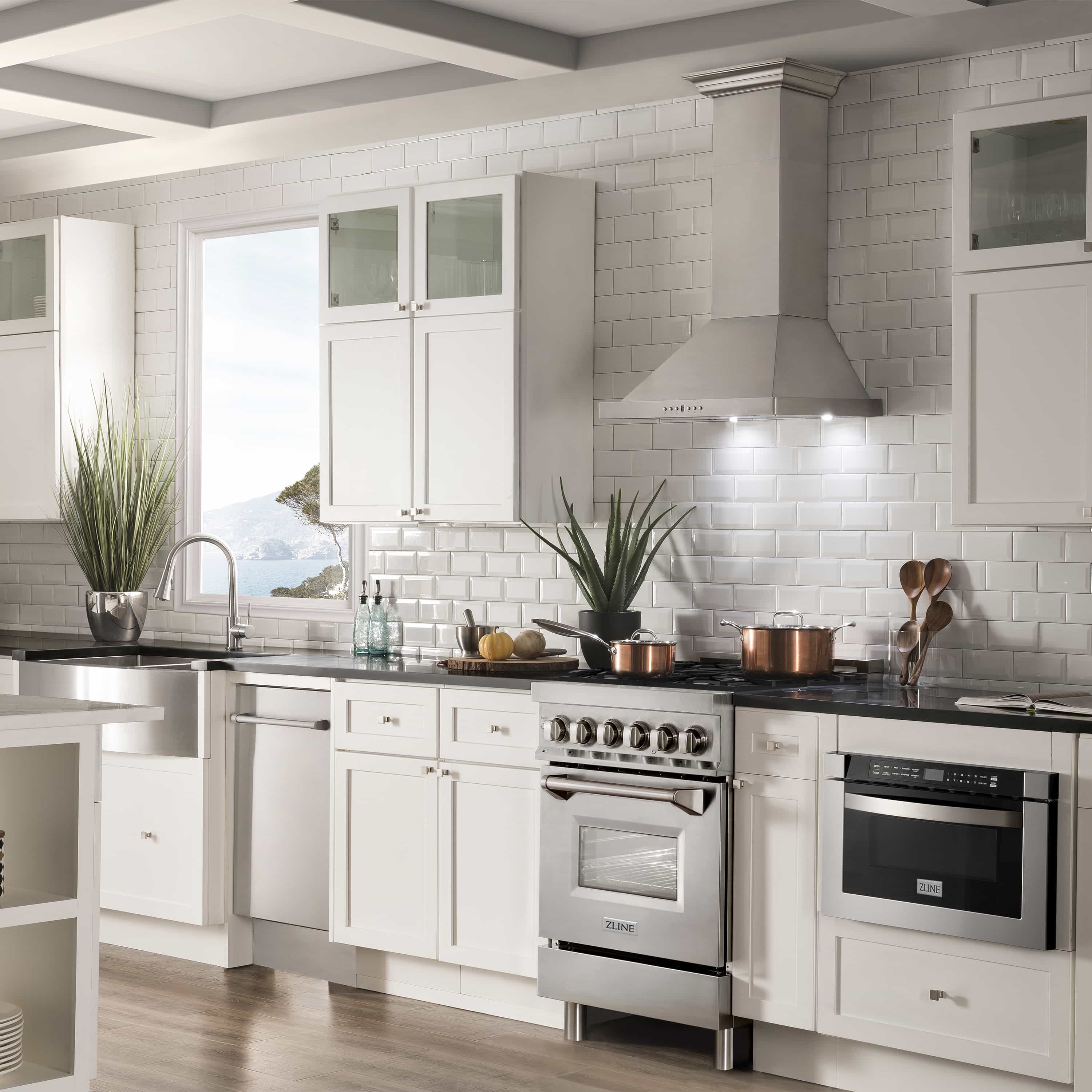 Stainless steel dual fuel range with black griddle and oven door in white kitchen